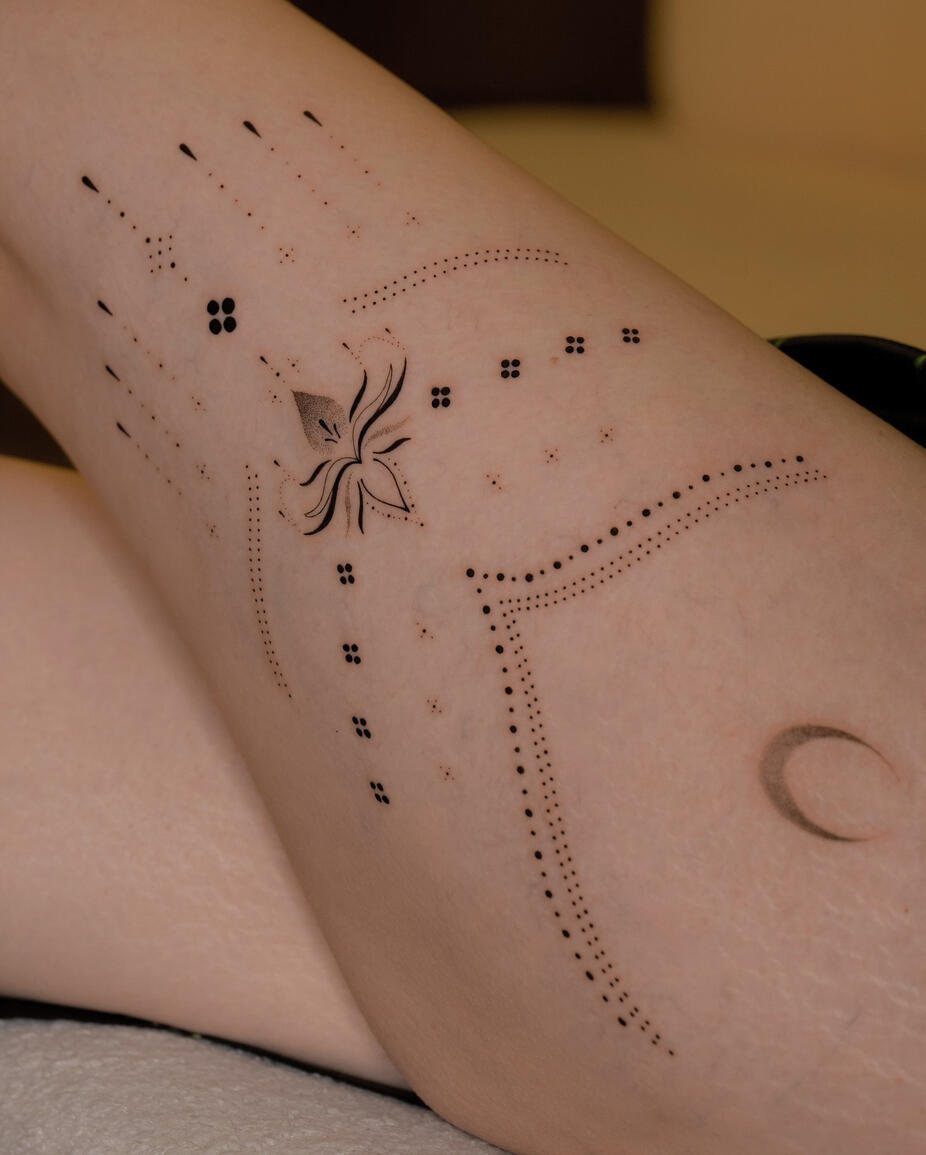 Tatuaggio delicato dotwork su gamba di donna a Roma con una luna