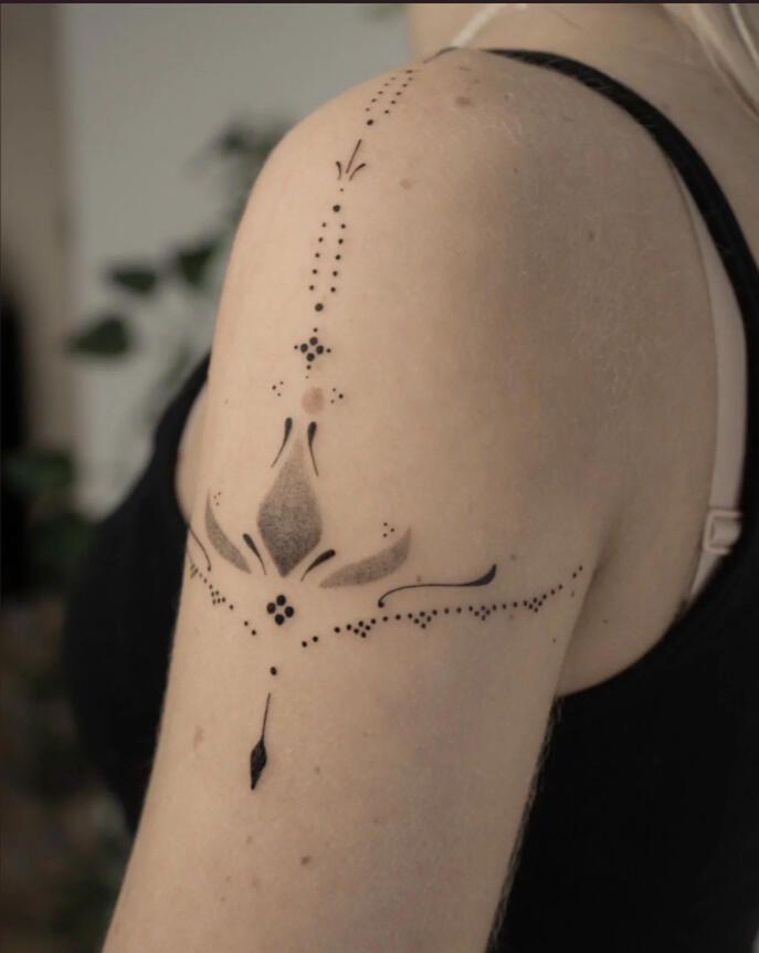 Tatuaggio su braccio di donna con puntini e dotwork